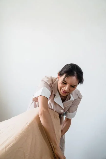 A mover carefully handles boxes in a bright, empty room on moving day.